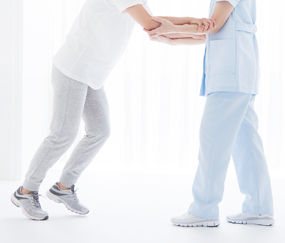 Image of a man holding on to the staff's arm and rehabilitating