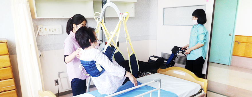 Image of moving an elderly woman with a nursing lift