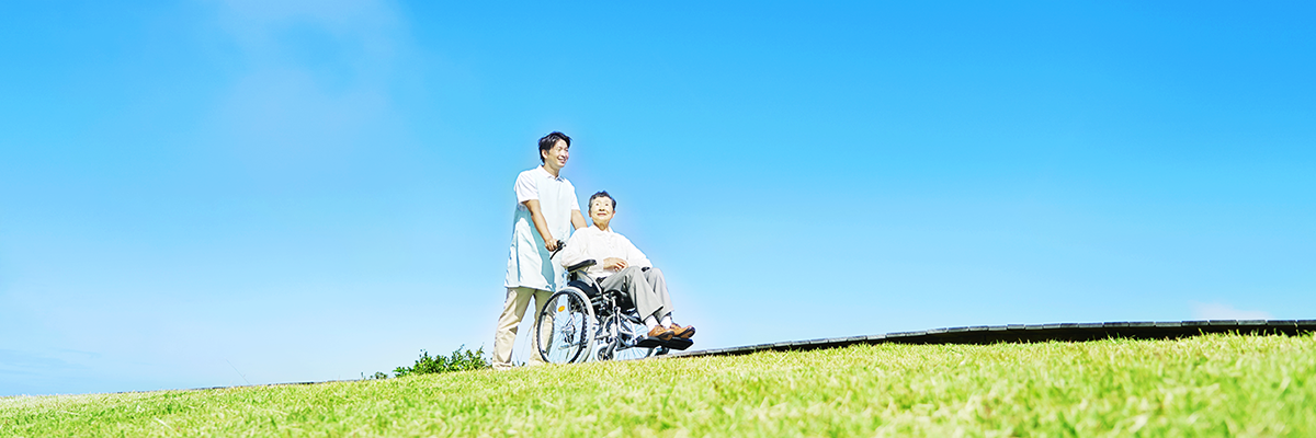 男性工作人员为老年妇女推轮椅的图片